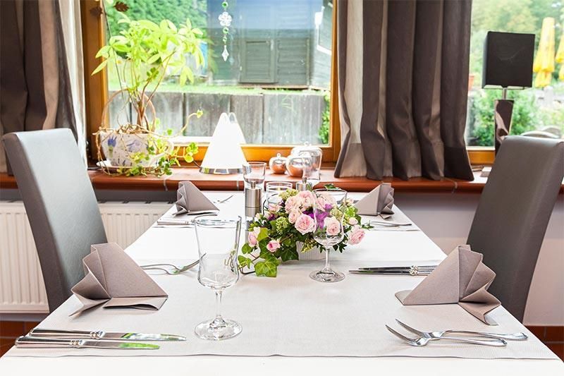 Ein Esstisch mit einer Vase mit Blumen darauf