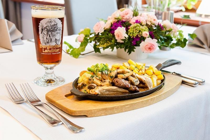 Ein Teller mit Essen und ein Glas Bier auf einem Tisch