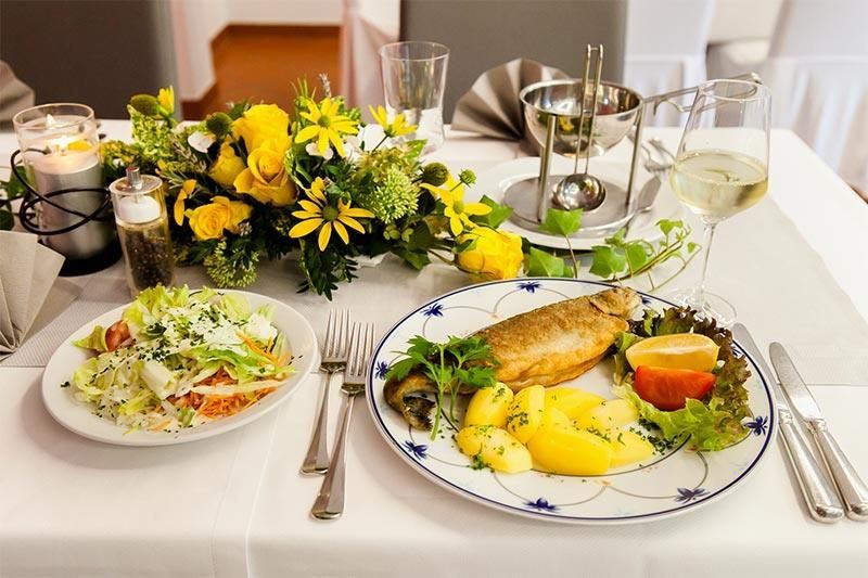 Ein Tisch mit Tellern voller Essen und Blumen darauf