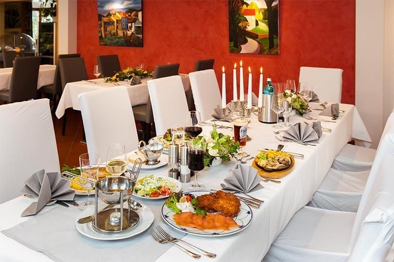 Ein langer Tisch mit Tellern voller Essen und Kerzen darauf