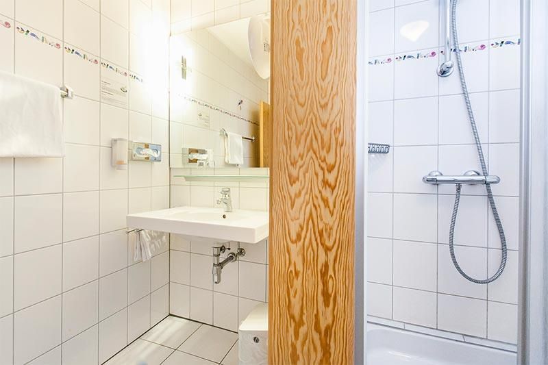 Ein Badezimmer mit Waschbecken, Dusche und Spiegel.