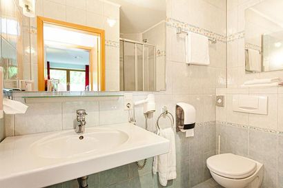 Ein Badezimmer mit Toilette, Waschbecken und Spiegel