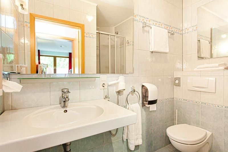 Ein Badezimmer mit Toilette, Waschbecken und Spiegel