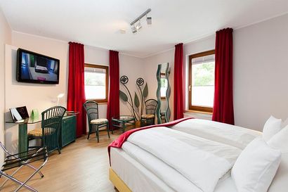 Ein Hotelzimmer mit einem großen Bett und einem Flachbildfernseher