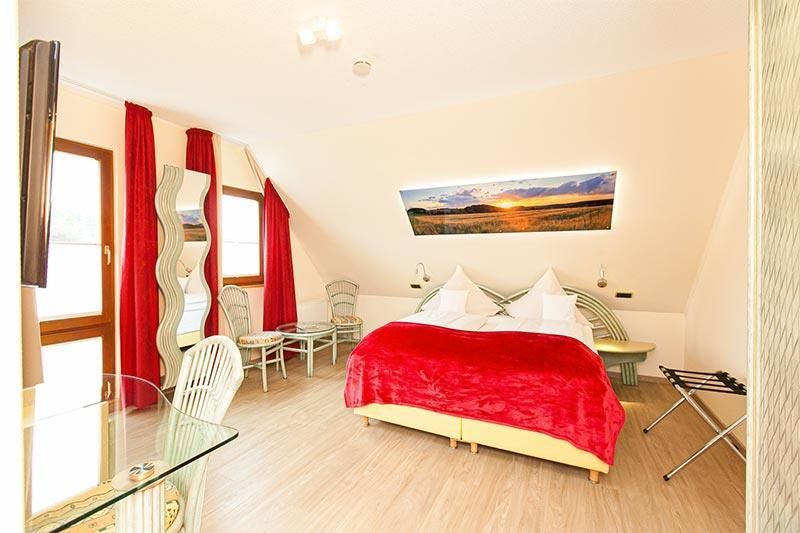 Ein Hotelzimmer mit einem großen Bett und einem Bild an der Wand