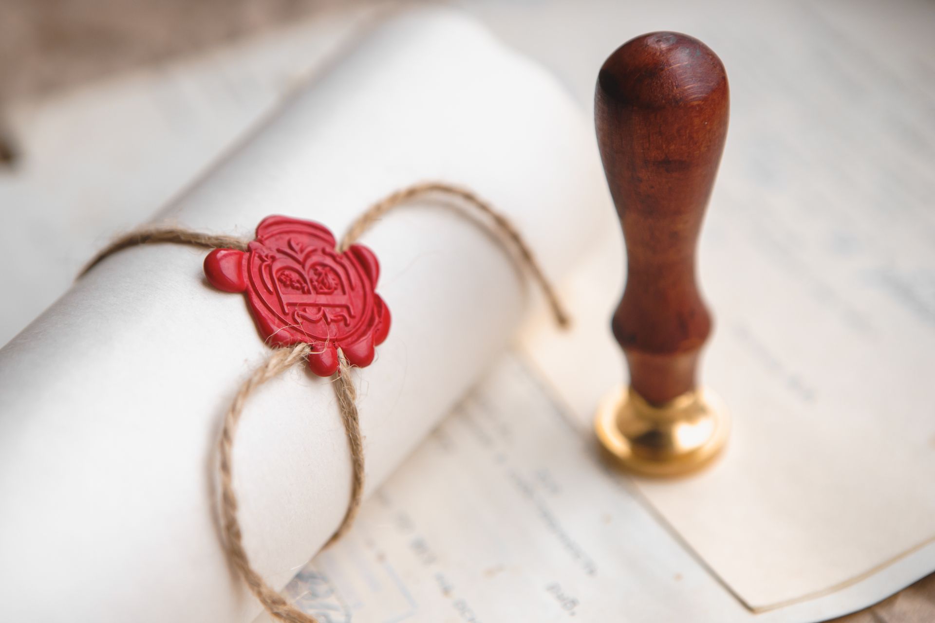 ein eingerolltes Dokument mit einem Siegel darauf und einem Siegelstempel