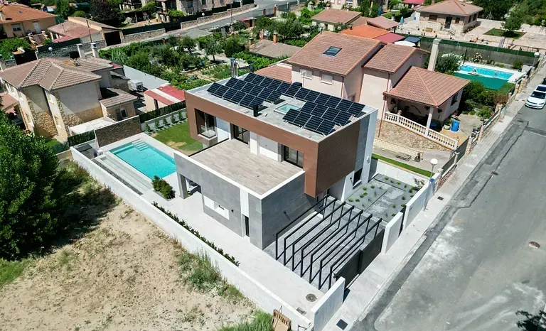 Una vista aérea de una casa con paneles solares en el techo.