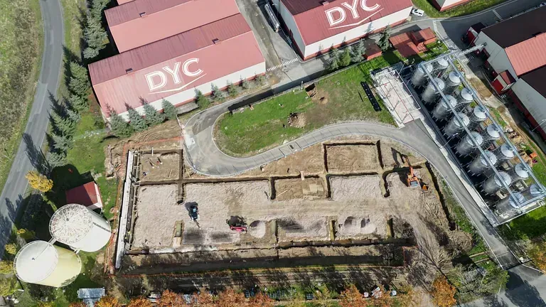 Una vista aérea de un sitio de construcción con edificios al fondo.