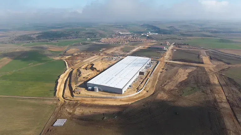 Una vista aérea de un gran edificio blanco en medio de un campo.