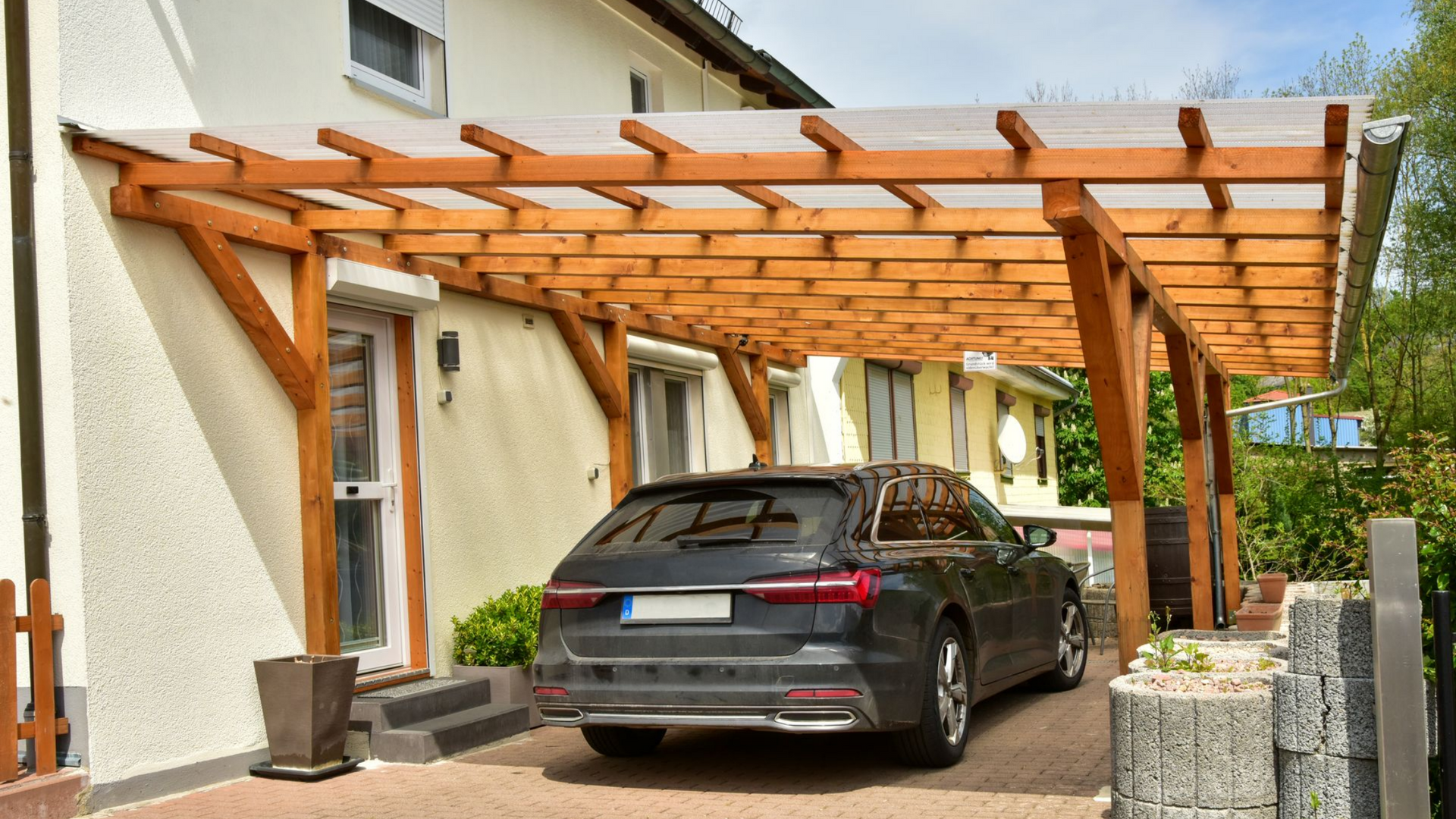 Aménagement d'un abri en bois pour véhicule collé à une maison