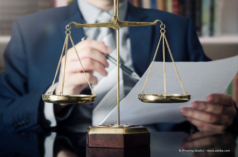 Waage auf Schreibtisch mit Anwalt