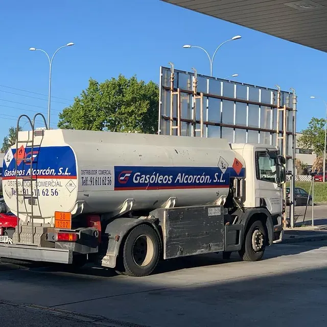 Un camión de gasolina está estacionado en una gasolinera.