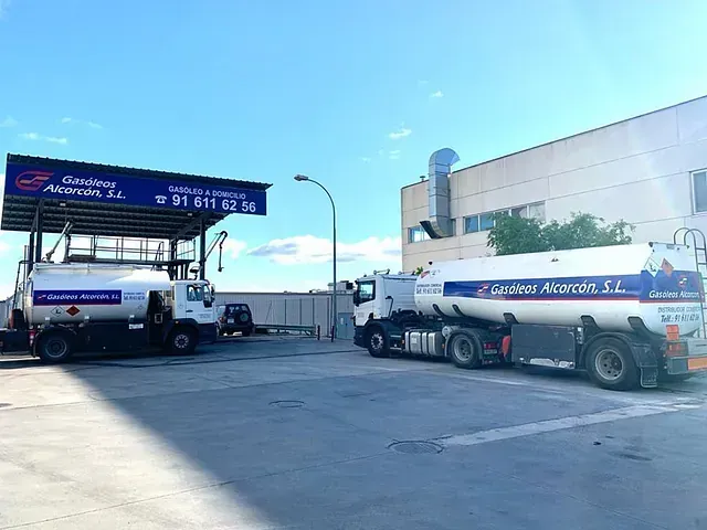 Dos camiones cisterna están estacionados uno al lado del otro en un estacionamiento.
