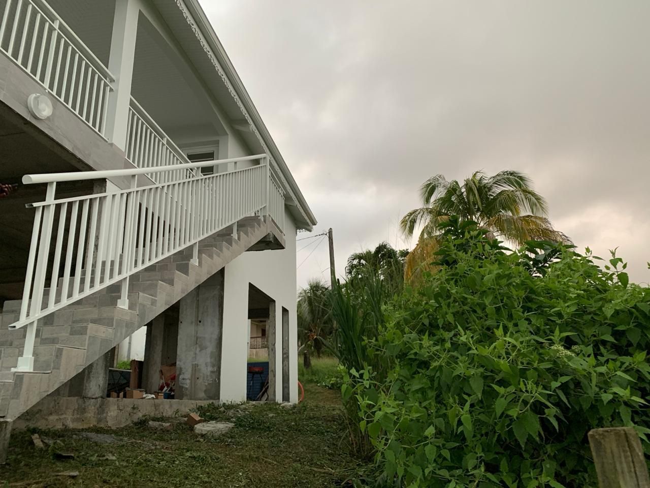 Maison blanche avec escalier, rampe blanche.