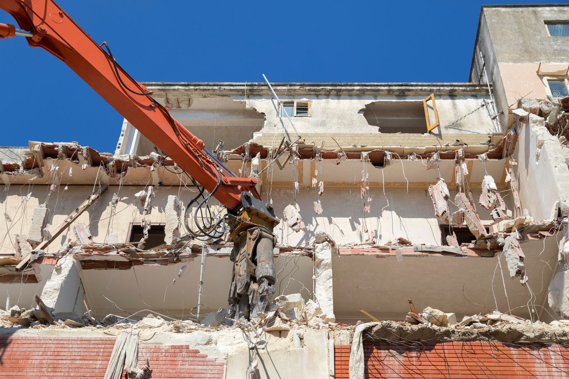 Démolition d'un mur avec une pelle de chantier