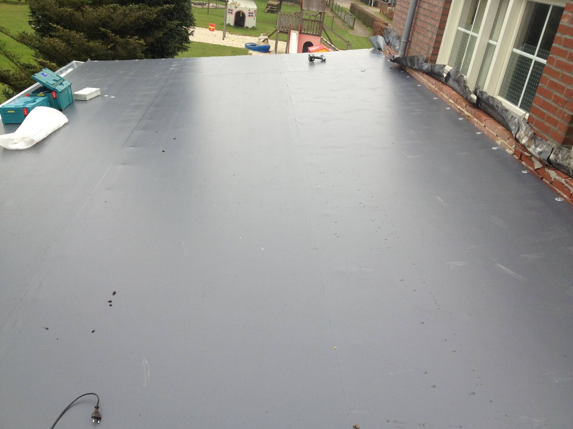 Ein robustes und widerstandsfähiges Flachdach für einen Anbau an ein bestehendes Haus.