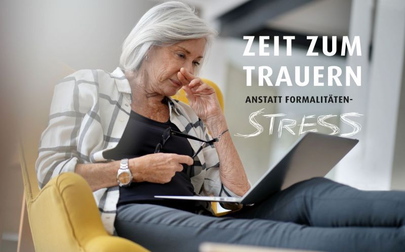 Eine ältere Frau sitzt auf einem Stuhl und benutzt einen Laptop.