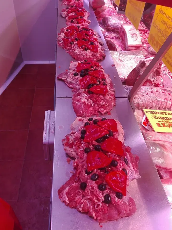Exhibición de panadería con panes de postre de fresa glaseados de rosa y cubiertos con bayas.