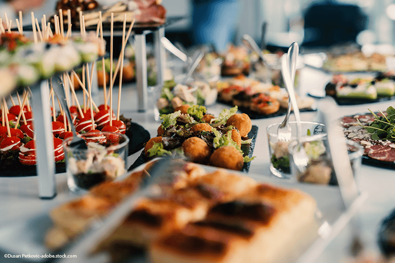 Buffet mit Vorspeisen: Spieße, frittierte Bällchen, Sandwiches und Aufstriche.