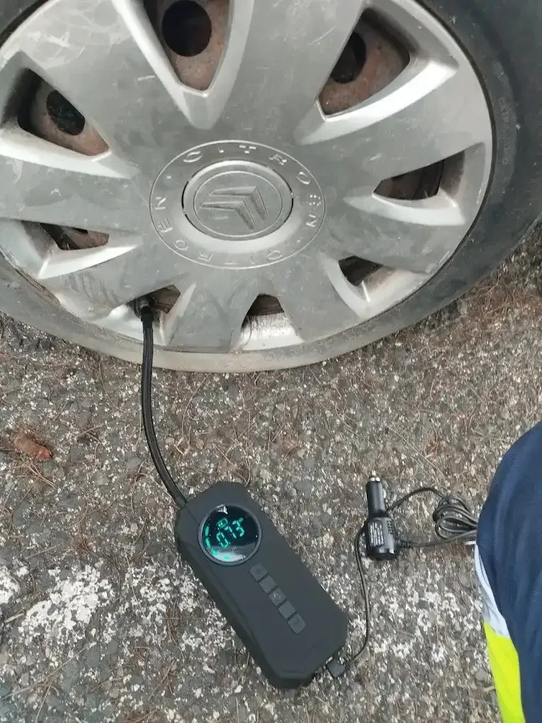 Un inflador de neumáticos está conectado a la válvula de un neumático de un coche.