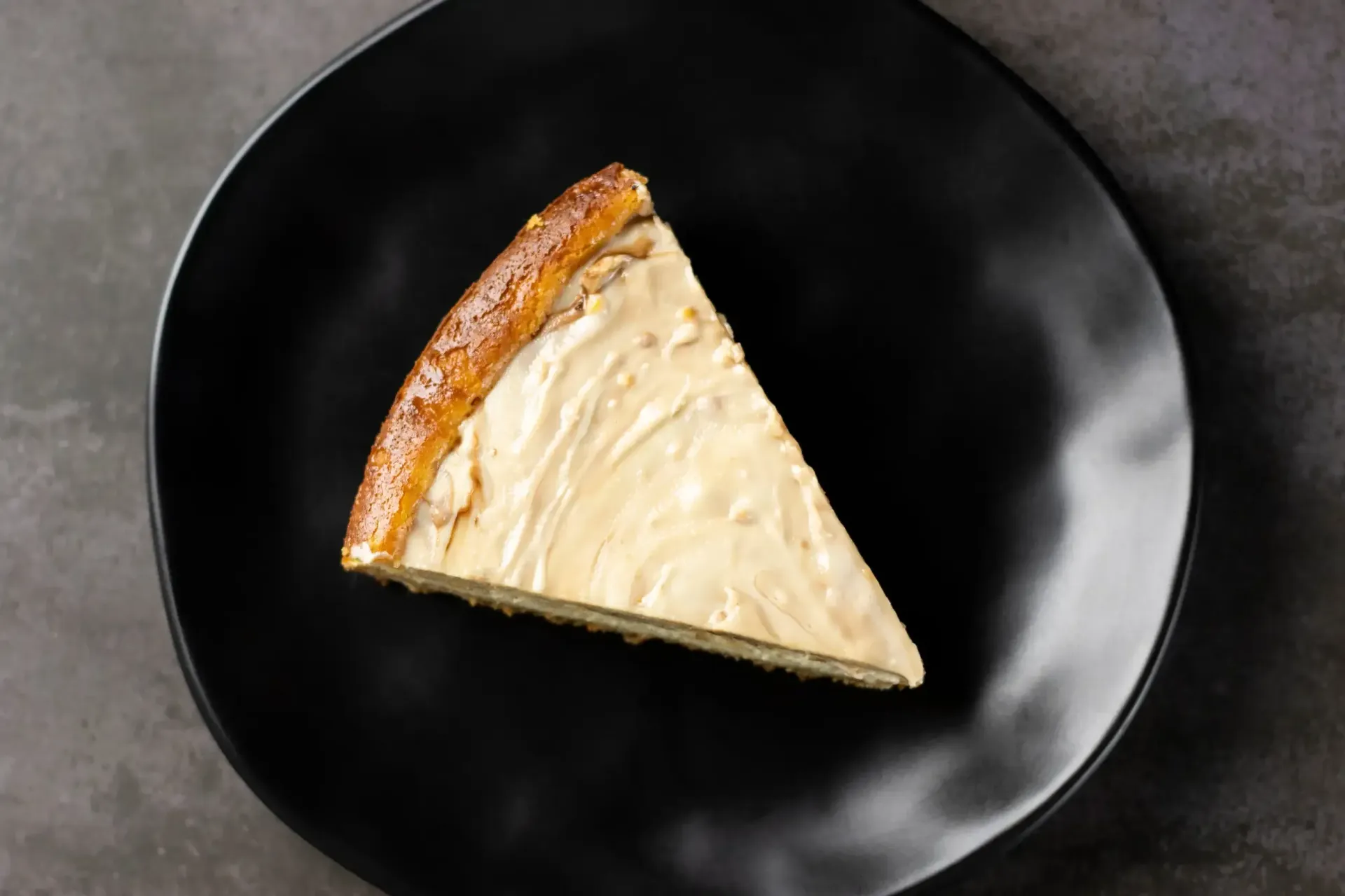 Una sola porción triangular de tarta de queso cremosa.