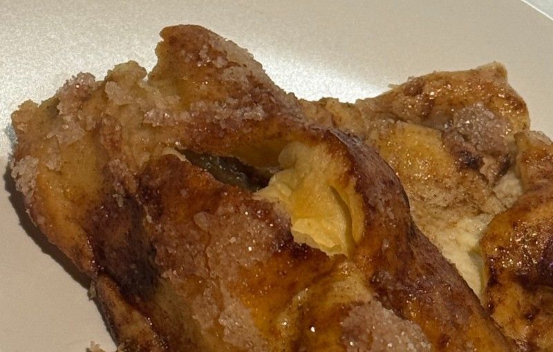 Primer plano de una masa de color marrón dorado con corteza azucarada, que revela un interior suave y amarillo.