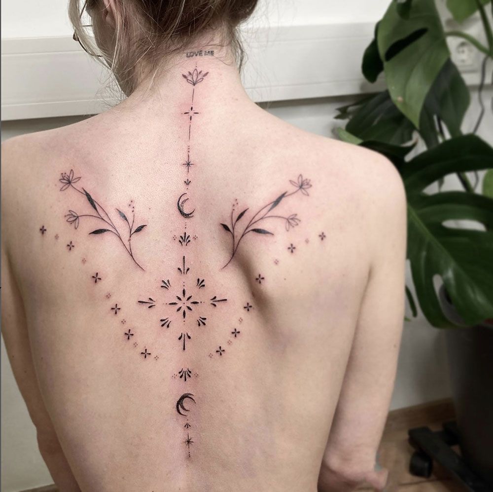 Eine Frau hat ein Tattoo auf dem Rücken, das wie ein Kompass aussieht