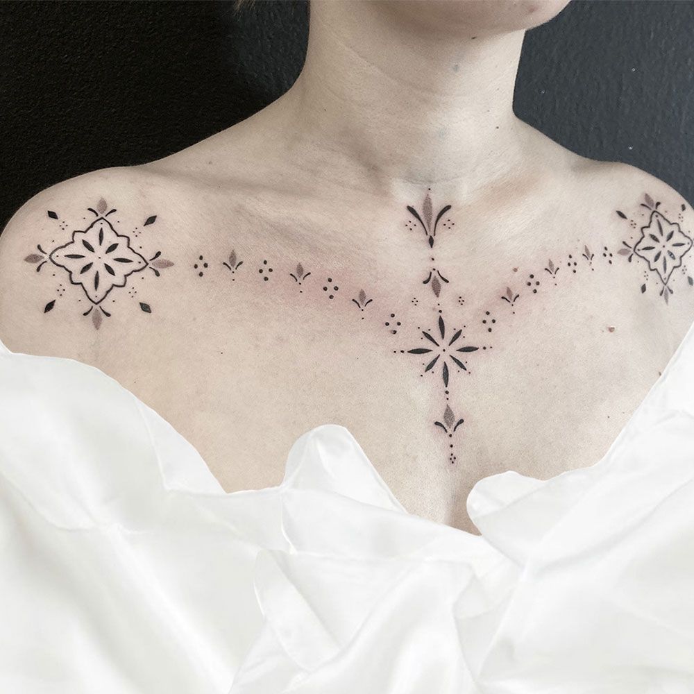 Eine Frau hat eine Tätowierung auf Brust und Schulter