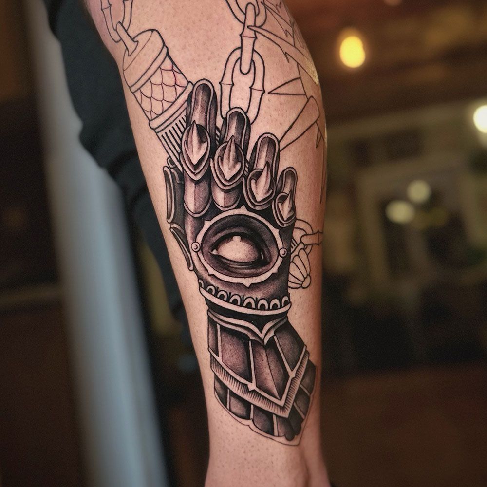 Eine Person hat eine Tätowierung eines Handschuhs auf ihrem Bein