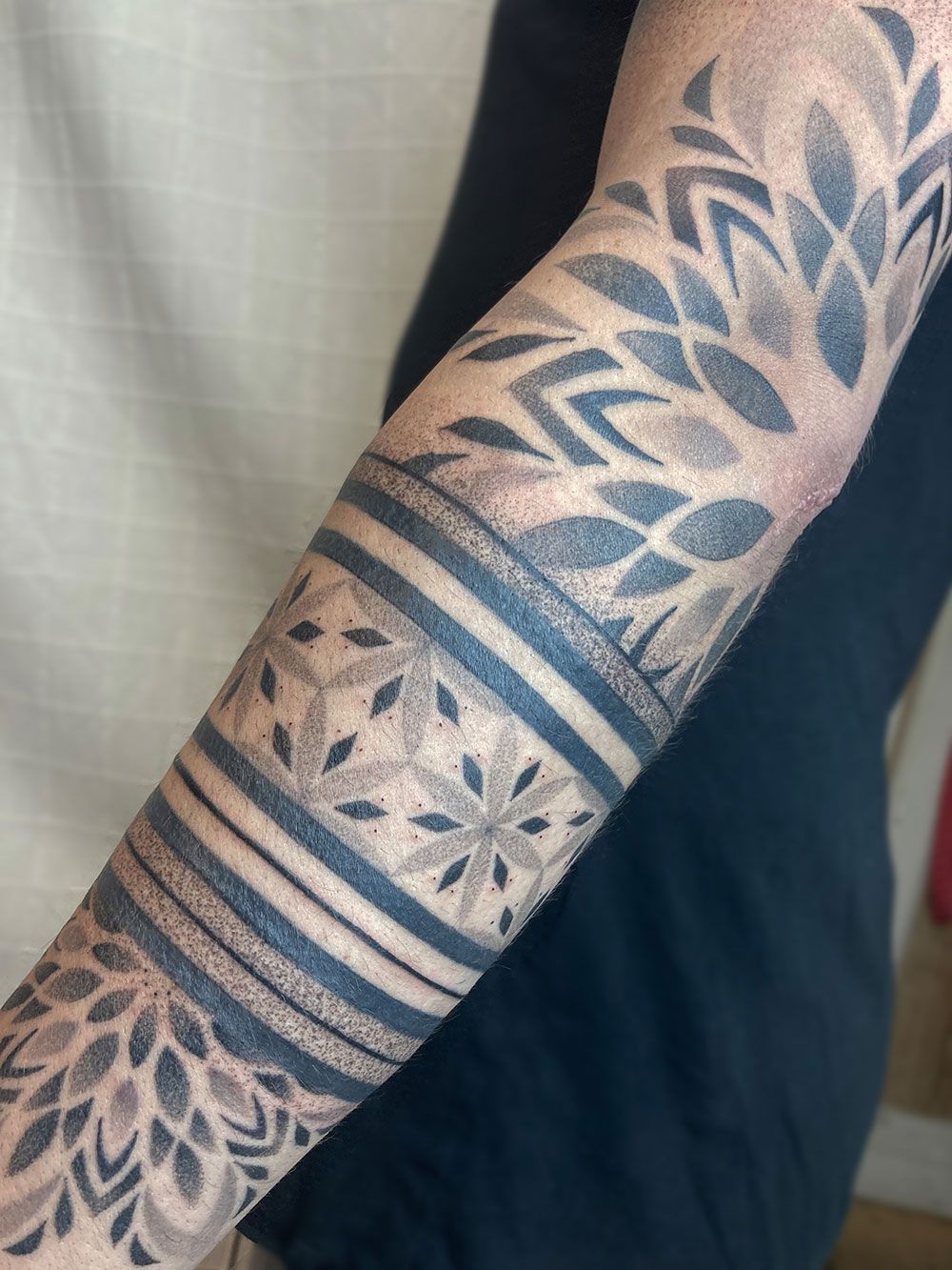 Eine Nahaufnahme des Arms einer Person mit einer Tätowierung darauf.