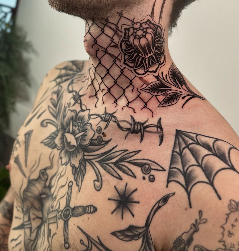 Ein Mann hat viele Tattoos auf der Brust und am Hals