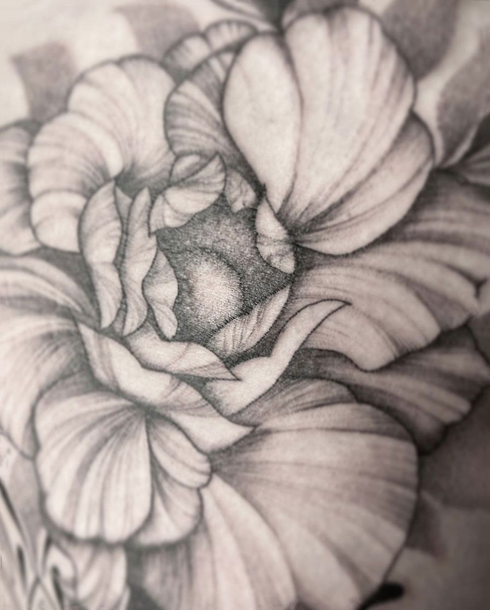 Eine Schwarzweißzeichnung einer Blume auf dem Arm einer Person.