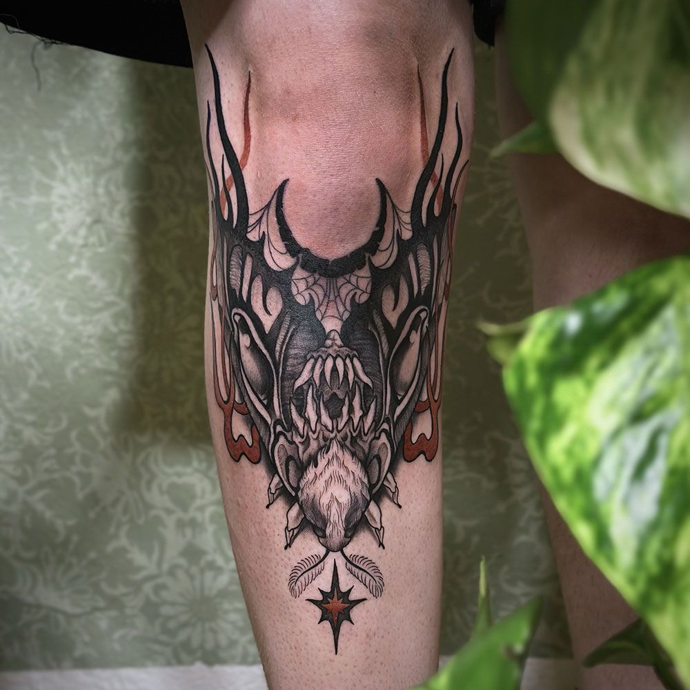 Eine Person hat eine Fledermaustätowierung auf ihrem Bein.