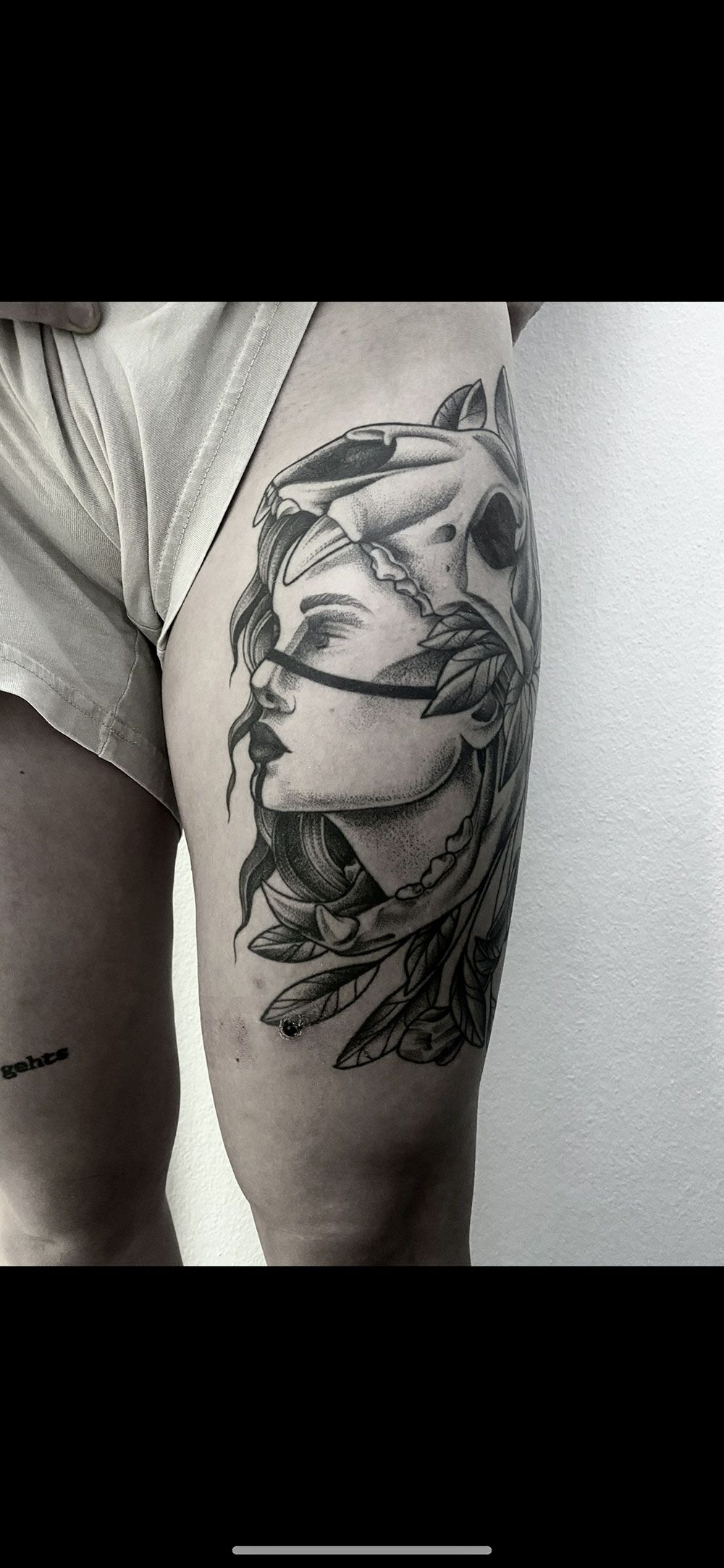 Ein Schwarzweißfoto einer Tätowierung auf dem Bein einer Frau.