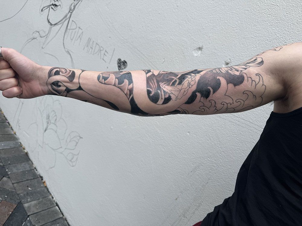 Ein Mann mit einer Tätowierung auf dem Arm hat eine Faust in der Luft