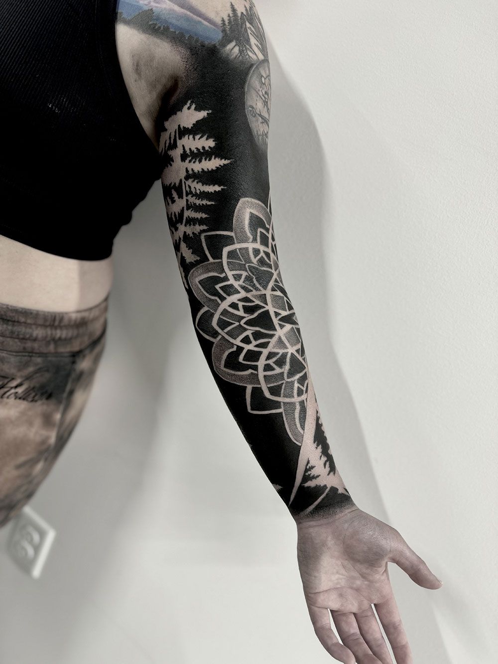 Eine Person mit einem schwarz-weißen Tattoo auf dem Arm