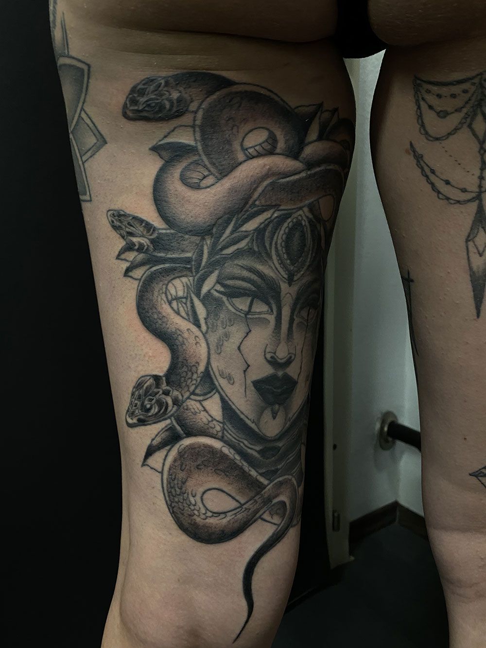 Eine Frau hat eine Medusa-Tätowierung auf ihrem Bein.