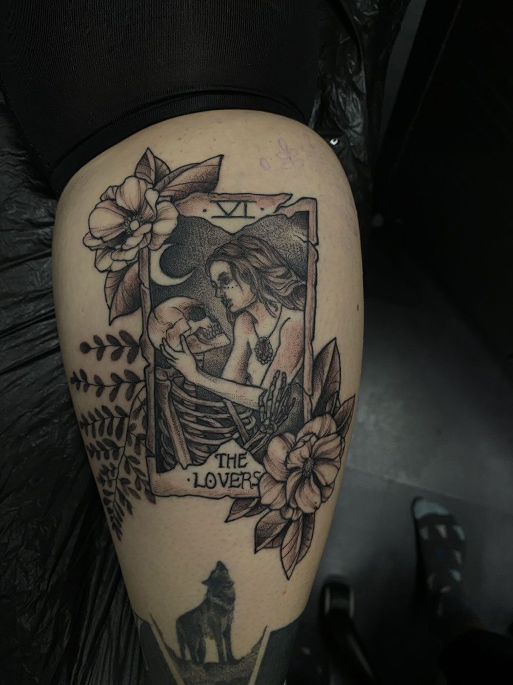 Eine Frau hat eine Tarotkarte auf ihrem Bein tätowiert.