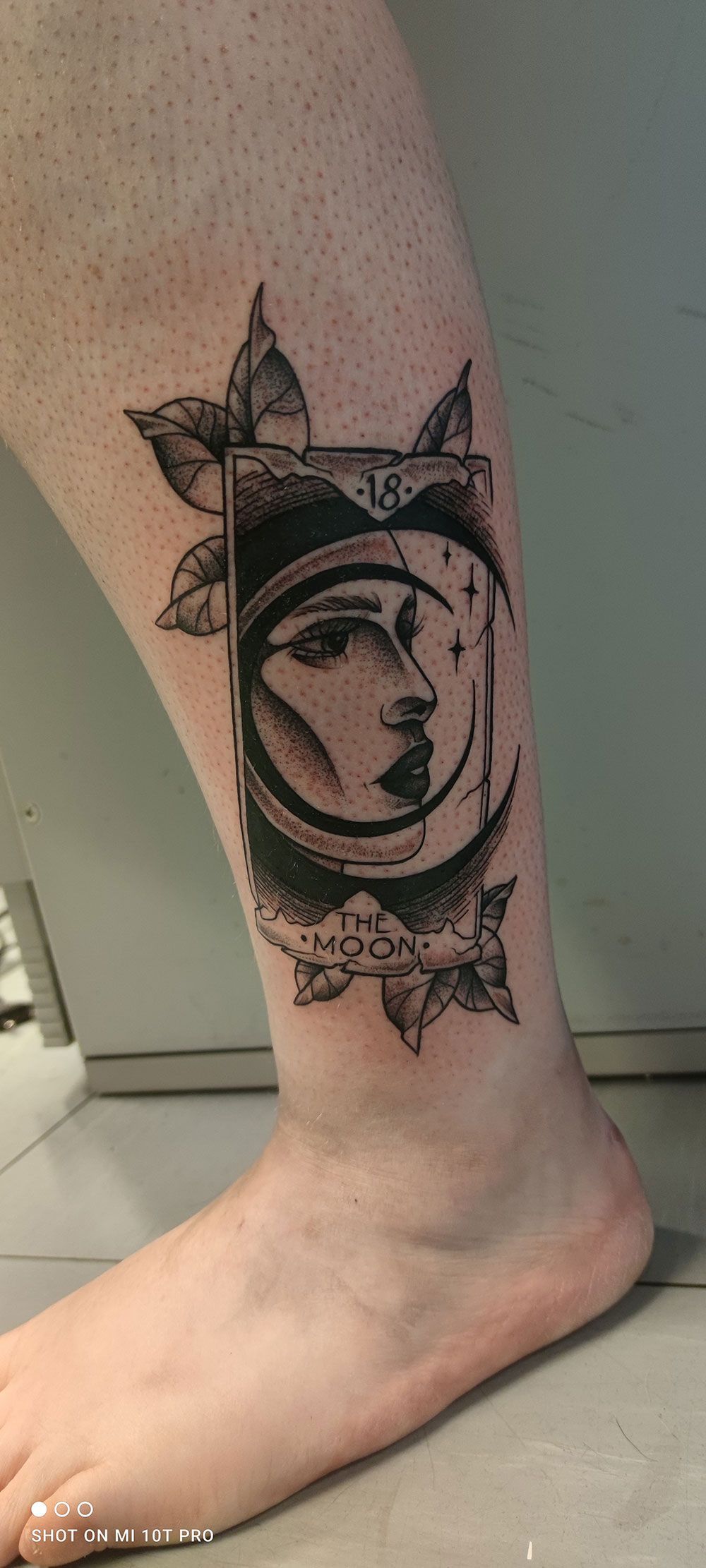 Eine Person hat eine Tätowierung mit dem Gesicht einer Frau auf ihrem Bein.