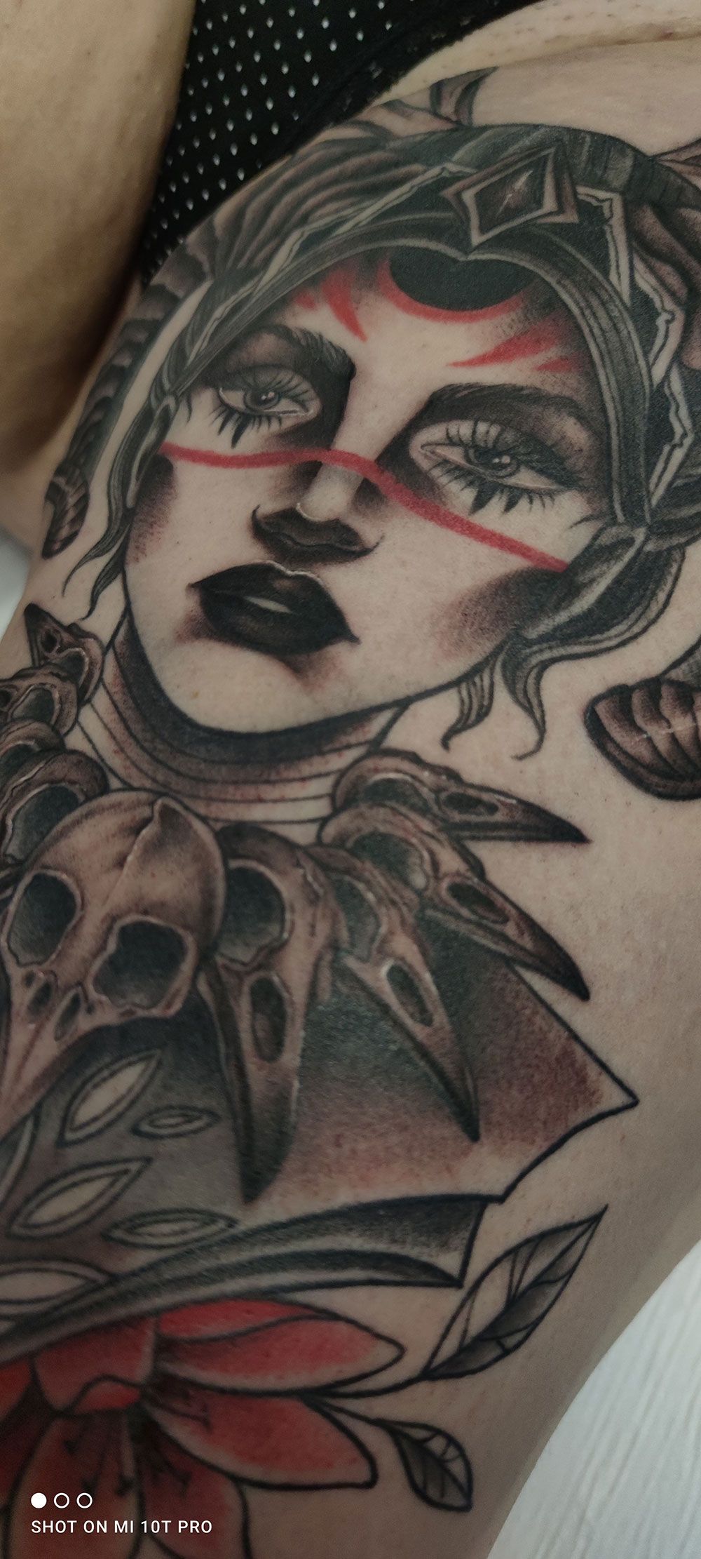 Eine Nahaufnahme der Tätowierung einer Frau mit Totenköpfen auf dem Arm.