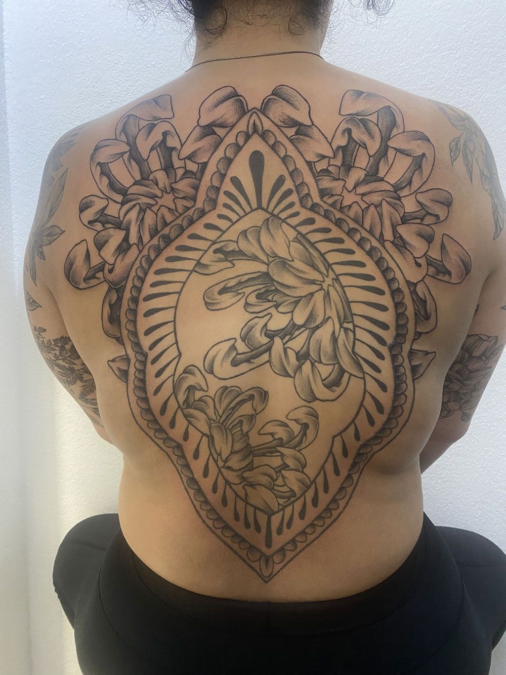 Eine Frau hat eine große Tätowierung auf ihrem Rücken.