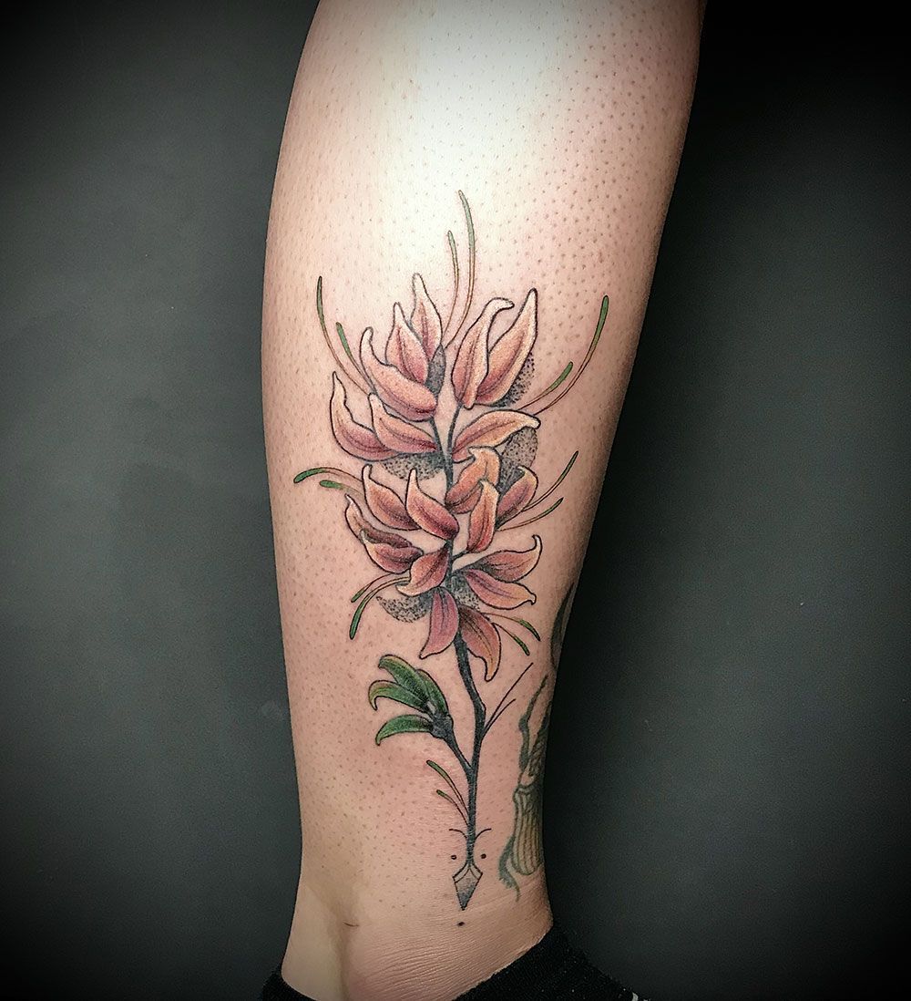 Eine Frau hat eine Blumentätowierung auf ihrem Bein.