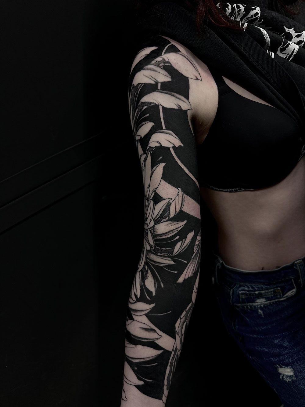 Eine Frau mit einer schwarz-weißen Tätowierung auf dem Arm.