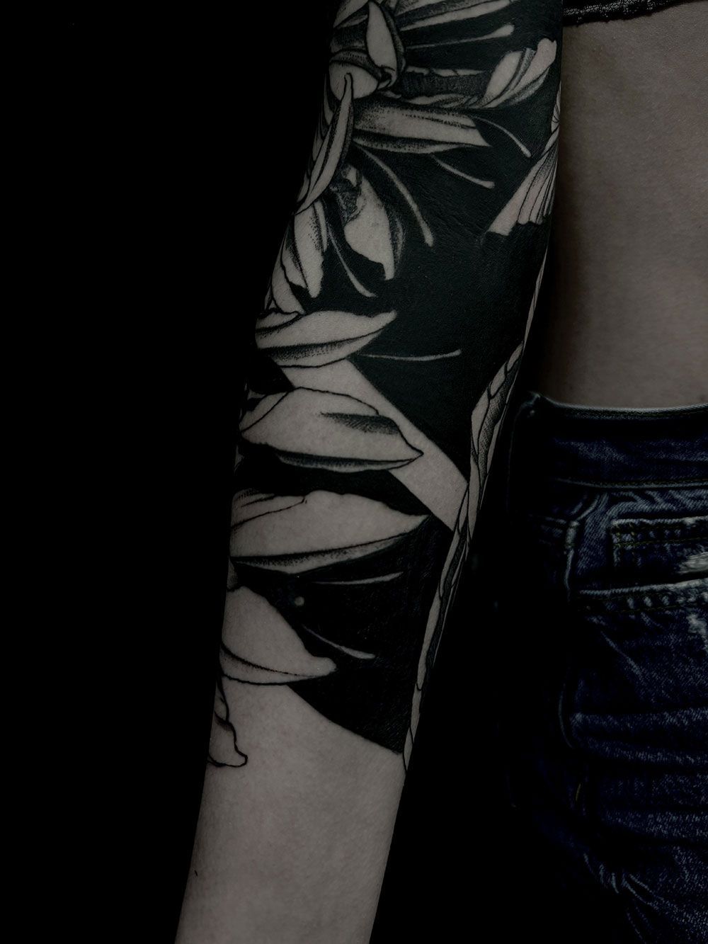 Eine Frau hat eine schwarz-weiße Tätowierung auf ihrem Arm.