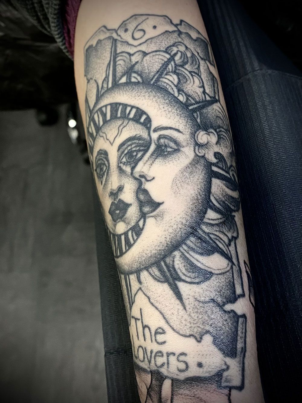 Ein schwarz-weißes Tattoo einer Freiheitsstatue und des Mondes