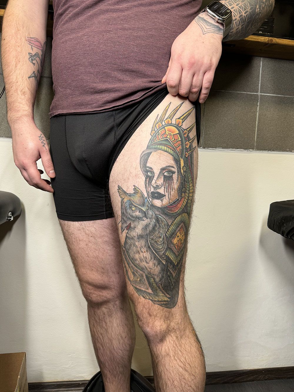 Ein Mann mit einer Tätowierung auf dem Bein trägt Unterwäsche.