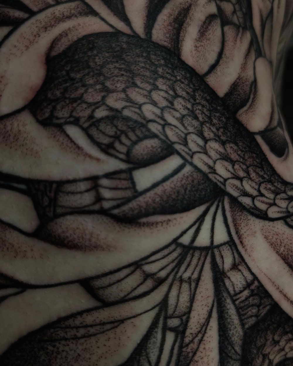 Eine Nahaufnahme einer Tätowierung einer Schlange auf dem Arm einer Person