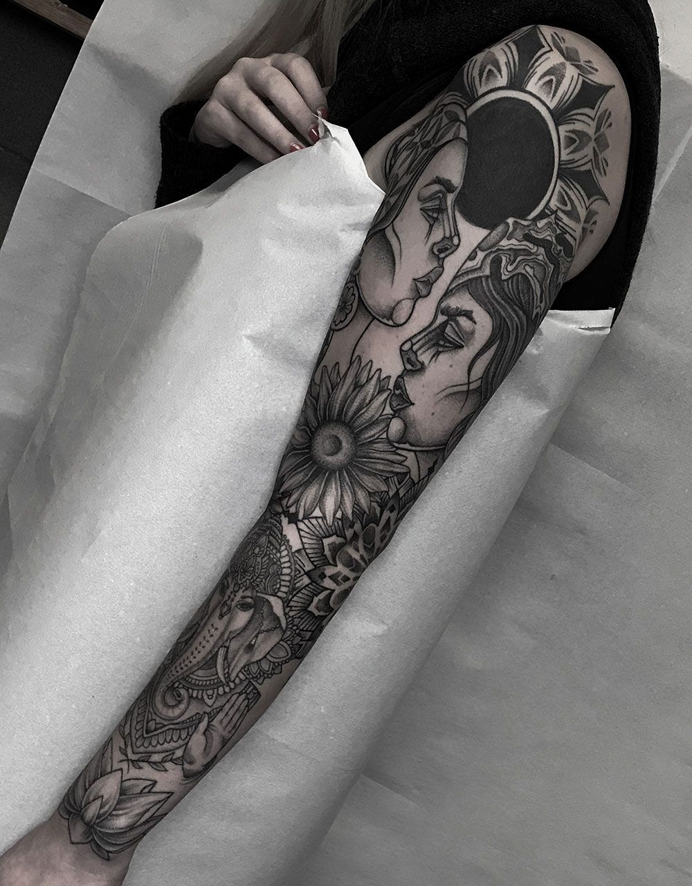 Eine Frau hat ein Tattoo auf dem ganzen Arm.