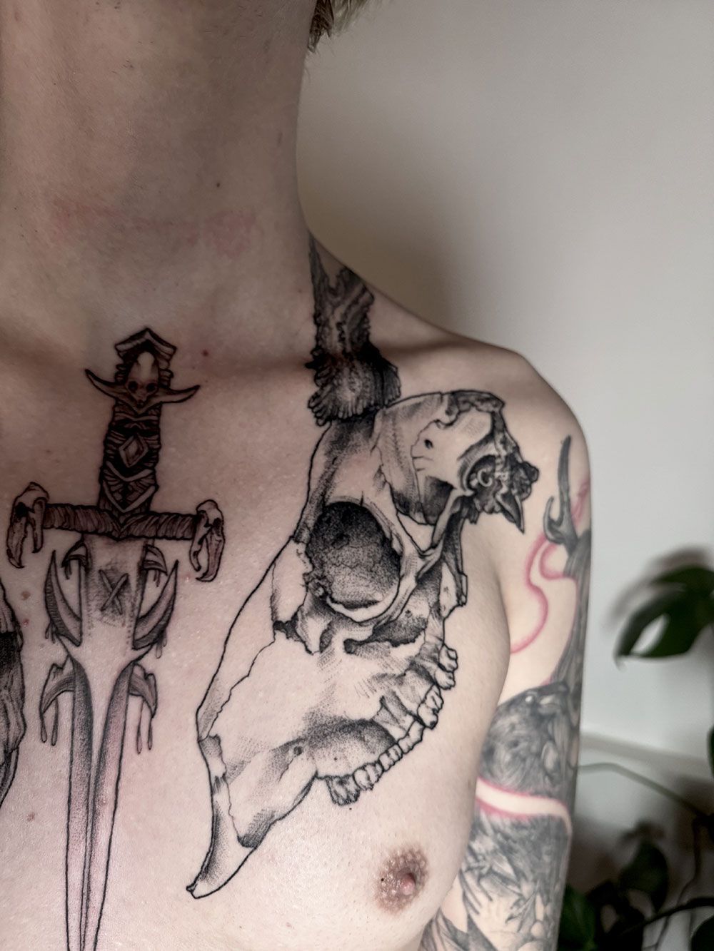 Ein Mann hat eine Totenkopftätowierung auf seiner Brust