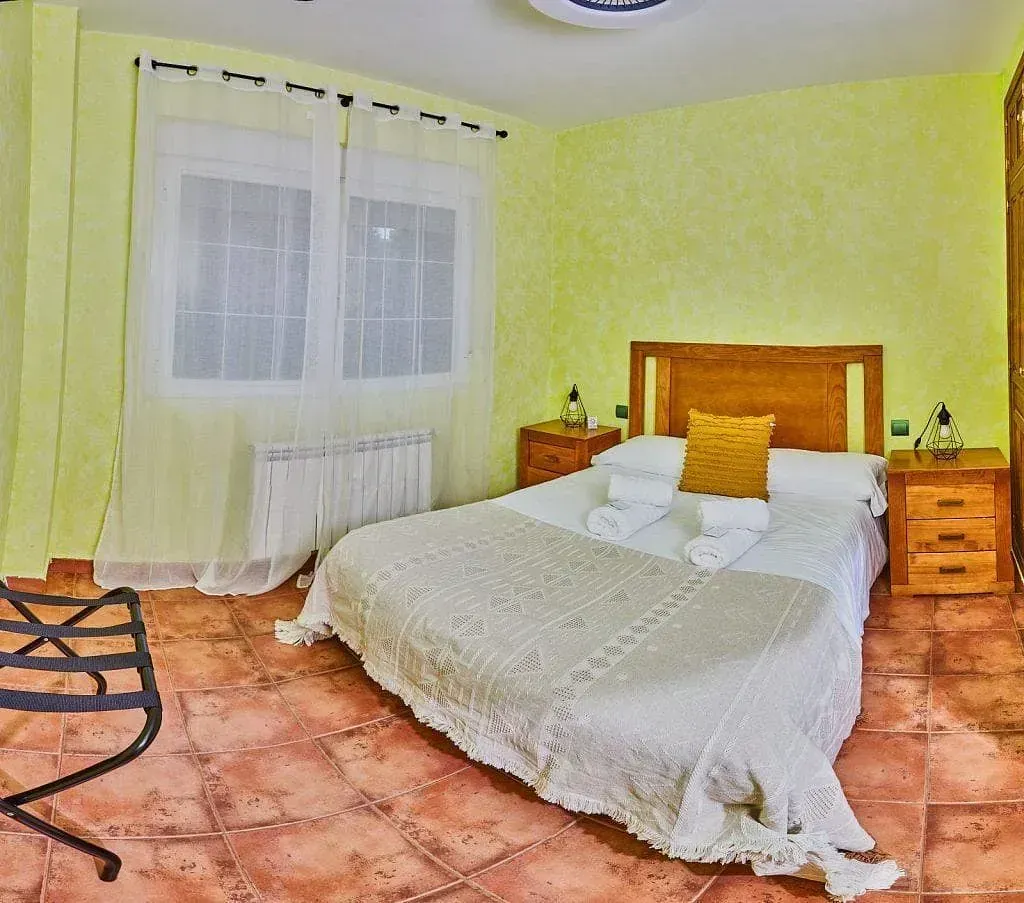 Un dormitorio con una cama grande y dos mesitas de noche.